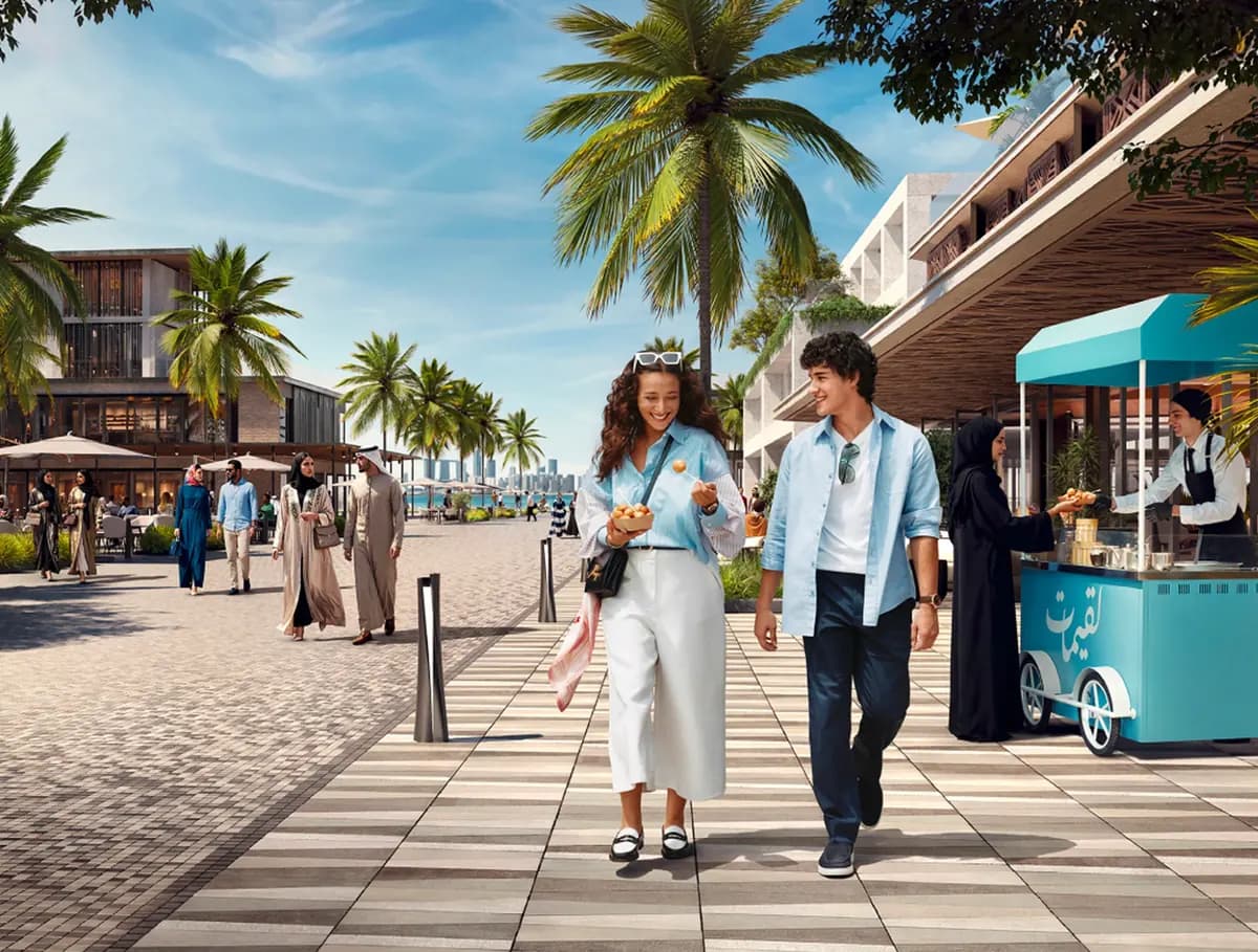 Developer rendering of the waterfront promenade with palms and cafés at Marsa Al Saadiyat